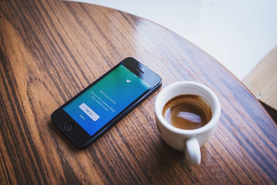 ツイッターにサインインしようとしているスマホと飲みかけのエスプレッソの画像
