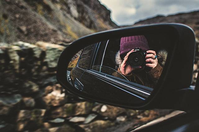 旅行中に自分のアイデンティティに悩むカメラを構えた女性の画像