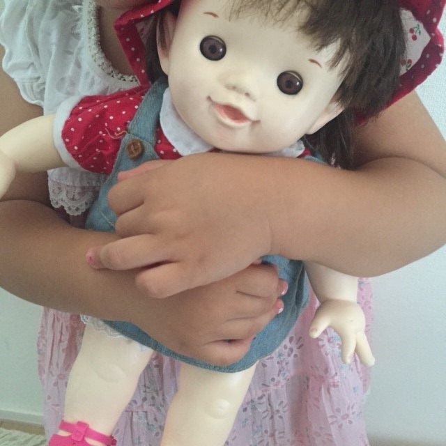 娘がぽーちゃん人形を抱えている写真